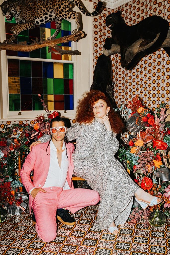 Bold maximalist wedding styling with oversized florals arranged against patterned tiled walls and vintage interiors.