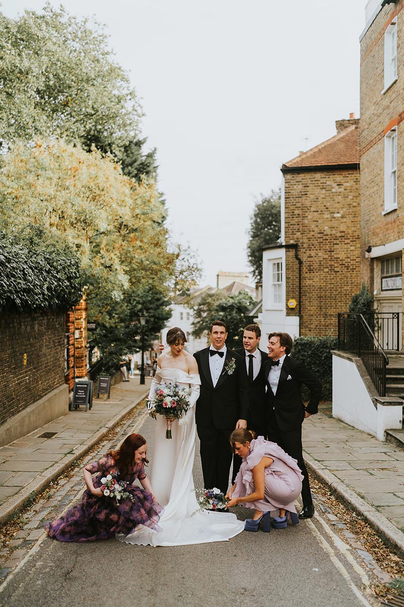 Wedding party on a quiet residential street in Hampstead, candid group portrait, Burgh House London wedding