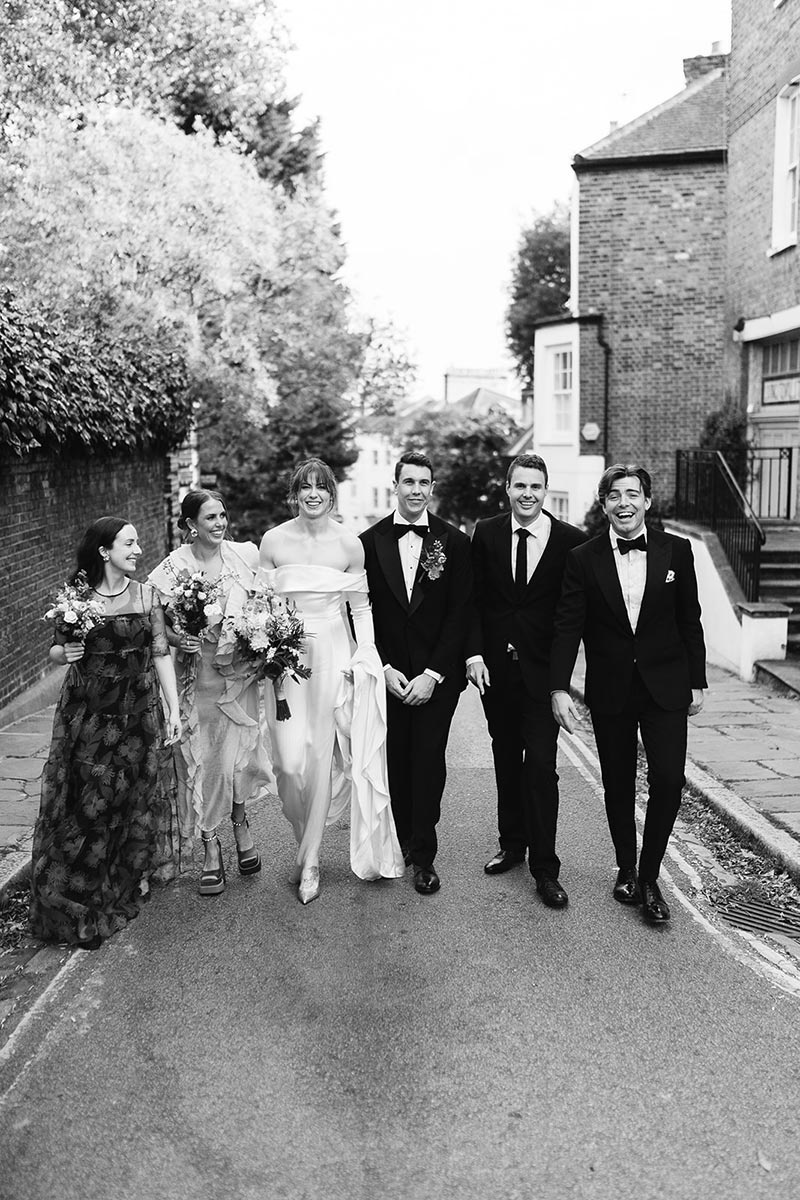 Wedding party on a quiet residential street in Hampstead, candid group portrait, Burgh House London wedding