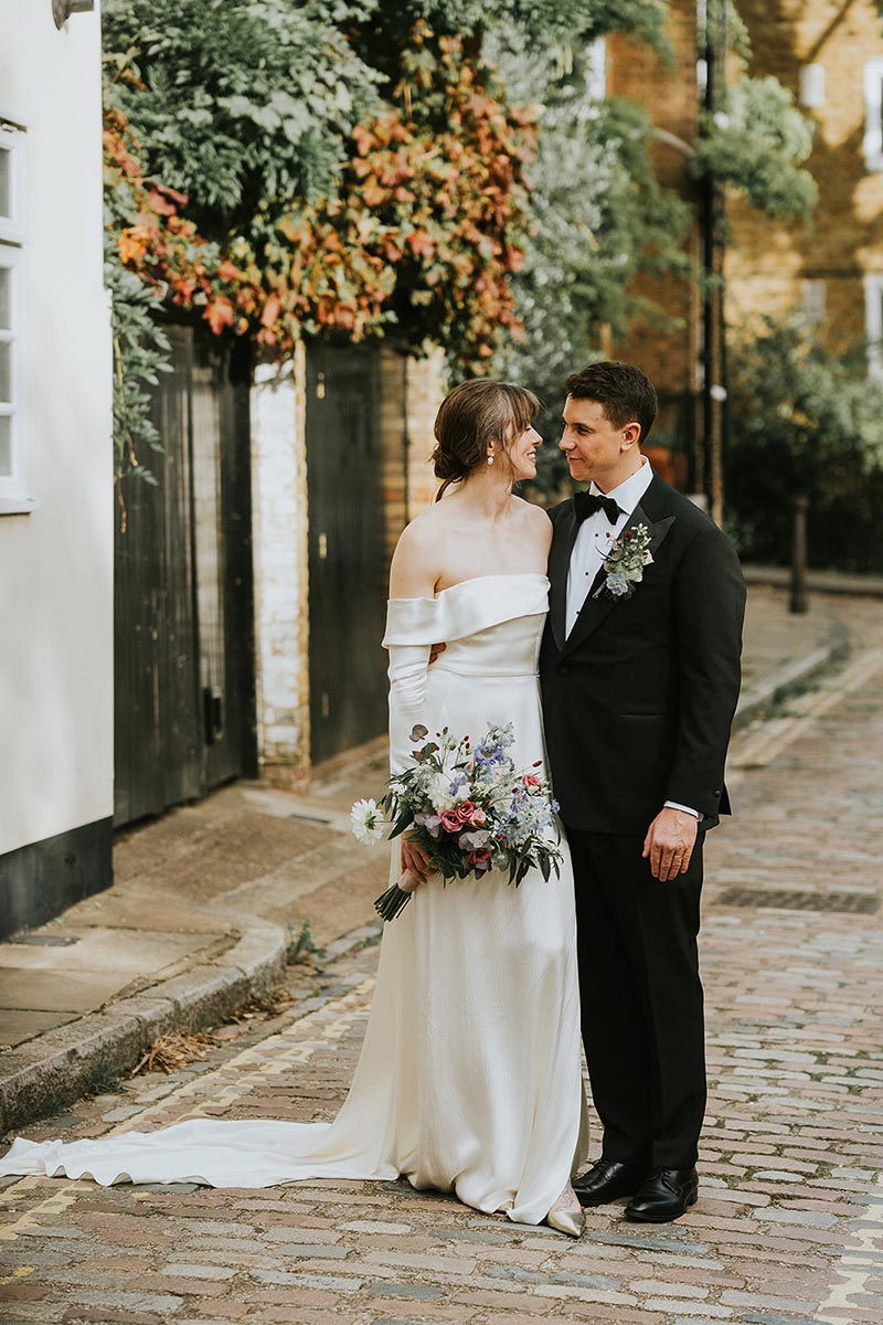 Bride and groom holding hands on a quiet residential street in Hampstead, editorial wedding portraits London
