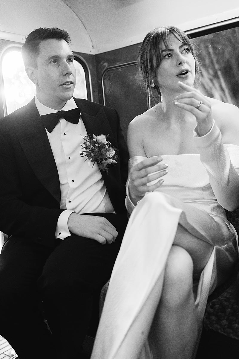 Bride and groom in candid conversation inside a London double decker bus, Burgh House Hampstead wedding