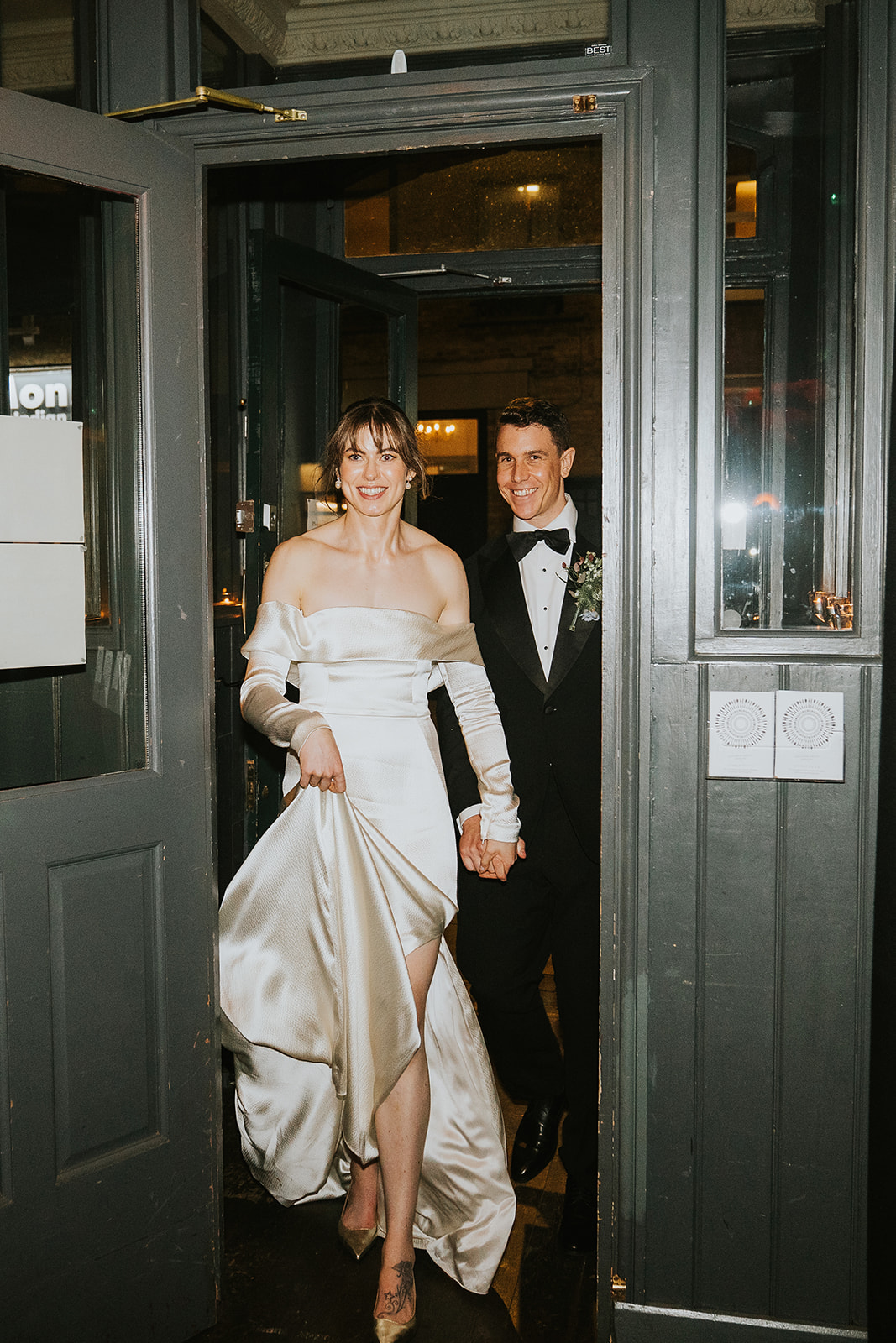 A couple walk into their wedding reception with the bride leading the groom at this London Wedding